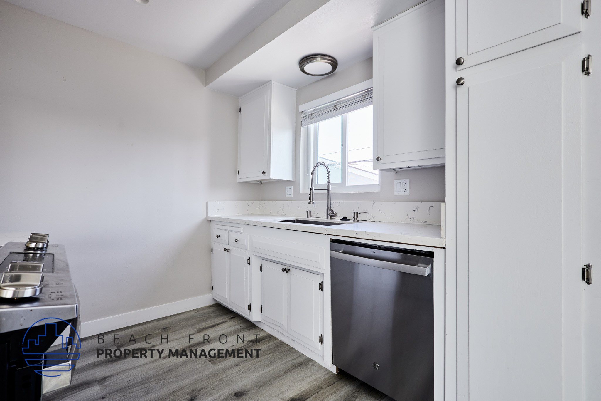 A kitchen with white cabinets and a stainless steel dishwasher.